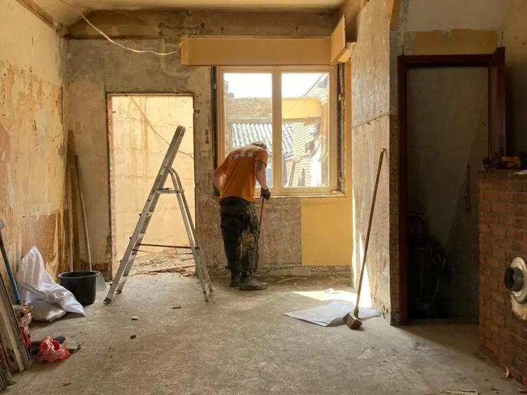 gestripte woning, vakman met kruiwagen