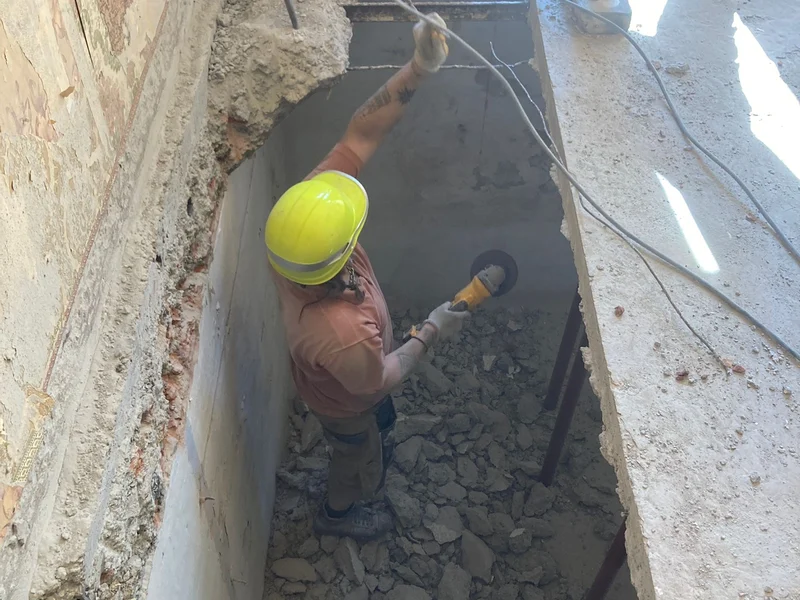 vakman met helm graaft trapopening