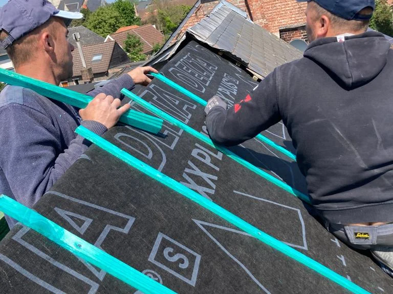 twee vaklui plaatsen onderdak op dakkapel, blauwe lucht