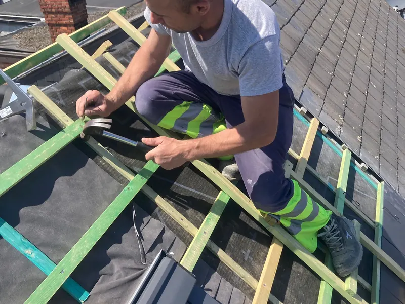vakman monteert velux in leien dak