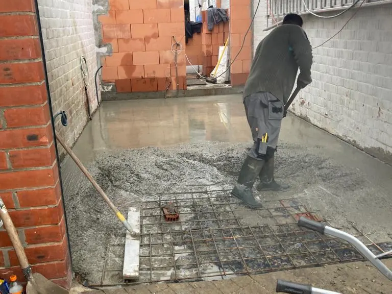 vloer storten, vakman met beton