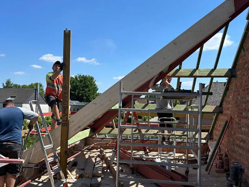 nieuwe houten spanten opgesteld, vakman op ladder