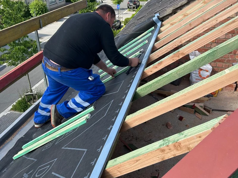 vakman legt onderdak op dakkapel