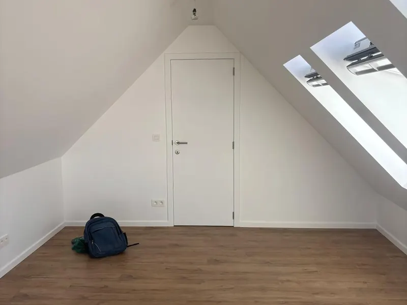 afgewerkte zolderkamer met laminaat en dakraam