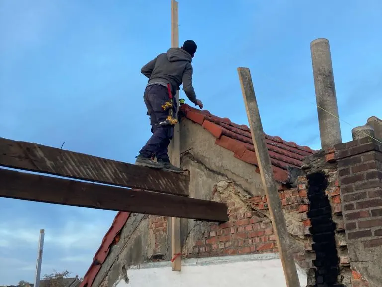 dakwerker op de nieuwe balklaag tegen blauwe lucht