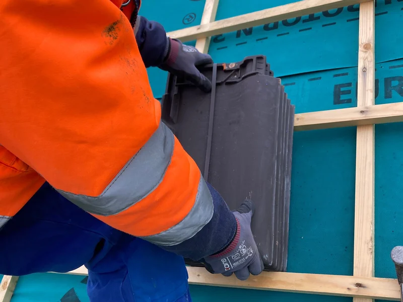 dakwerker in fluo legt nieuwe pannen