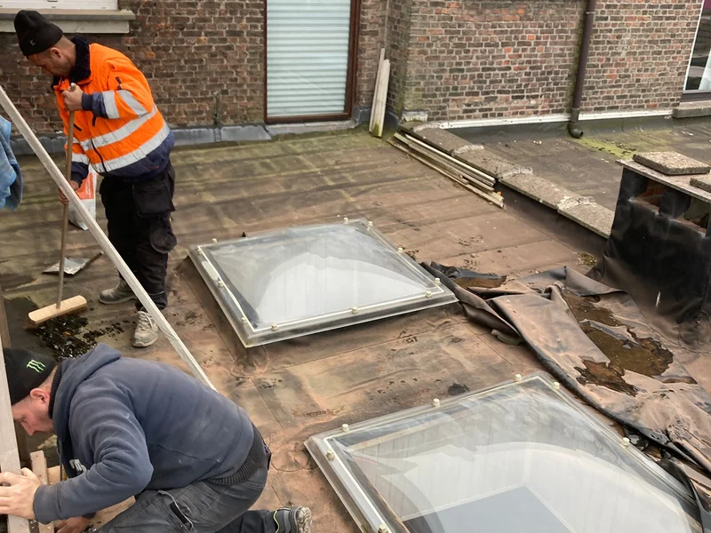 twee vaklui in fluo plaatsen lichtkoepels op plat dak