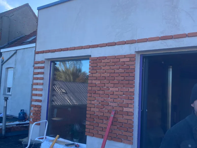 achterbouw met steenstrips en zwart raam vanuit tuin
