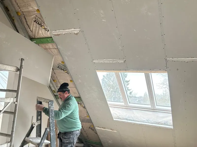 vakman bij dakraam met gyproc