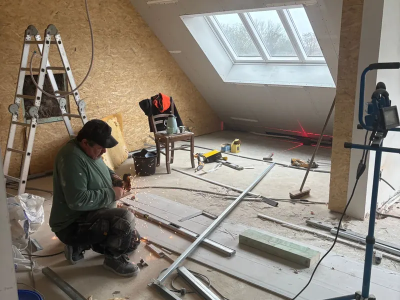 knieschot en dakraam, vakman aan het werk
