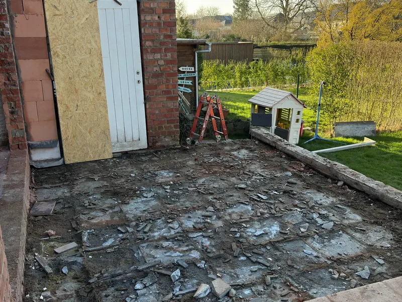 vakman breekt oude terrastegels uit