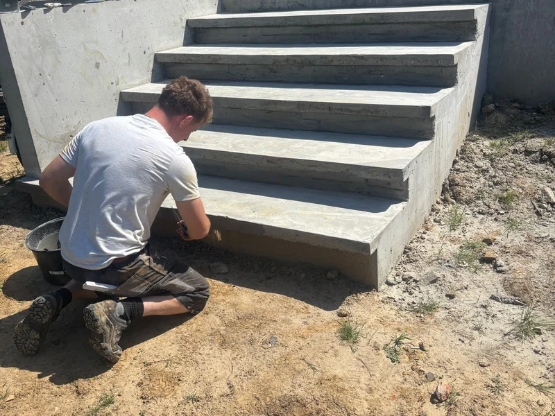 vakman werkt de nieuwe buitentrap af, zonnig