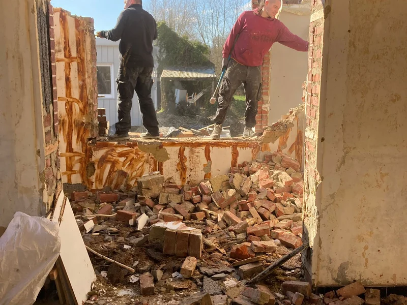 twee vaklui breken de oude aanbouw af