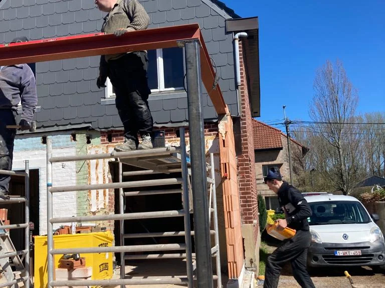 ploeg plaatst de stalen ligger op de muur