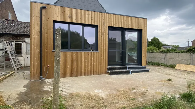 Afgewerkte uitbouw met houten gevelbekleding en grote ramen in Huldenberg, met architect