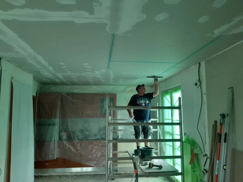 vakman op stelling monteert gyproc plafond