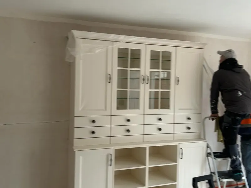 oude keuken met behang voor de werken, vakman op ladder