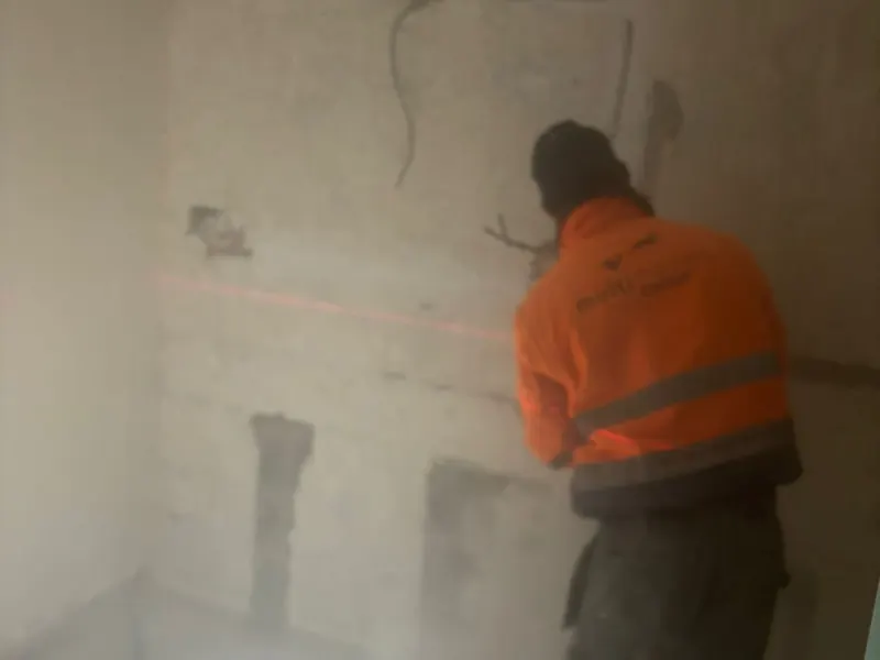 vakman slijpt sleuven, stof en licht
