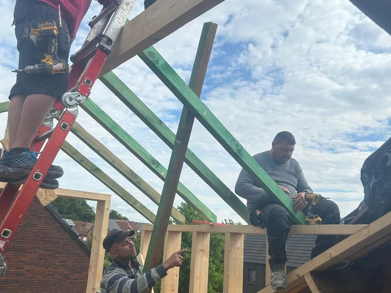 ploeg bouwt houten dakkapelstructuur