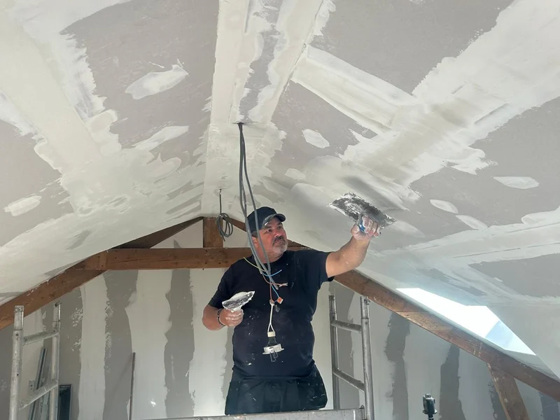 pleisteraar met spaan in zolderkamer