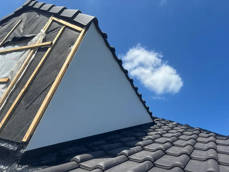 nieuwe dakkapel met witte bekleding en pannen, buiten
