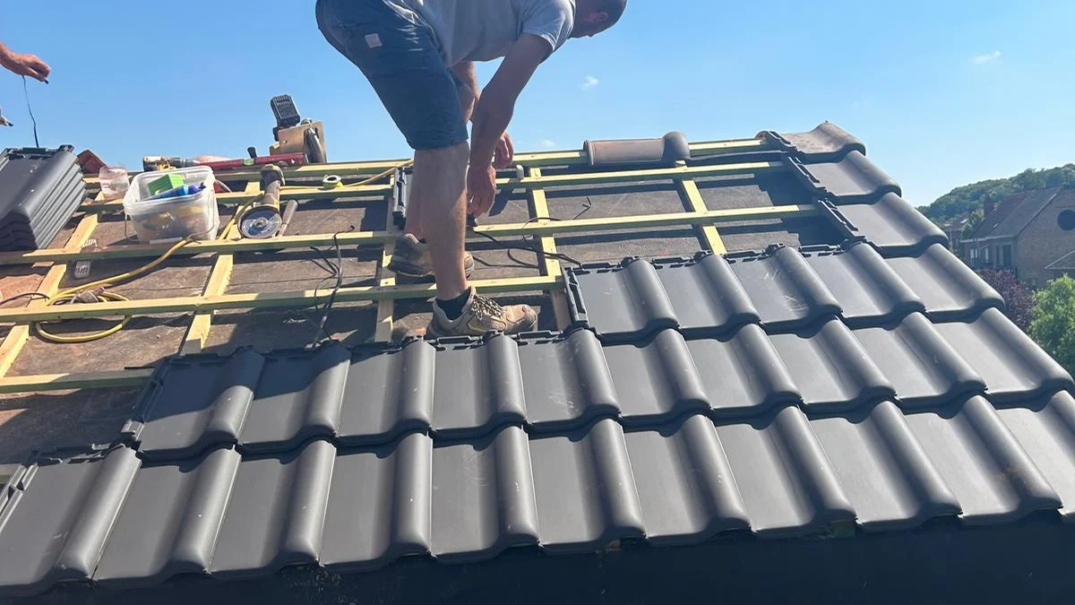 twee dakwerkers plaatsen pannen op de nieuwe dakkapel, blauwe lucht, sterk