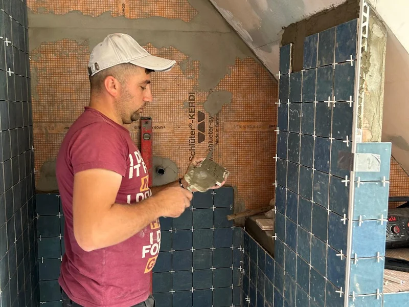 tegelzetter plaatst blauwe wandtegels
