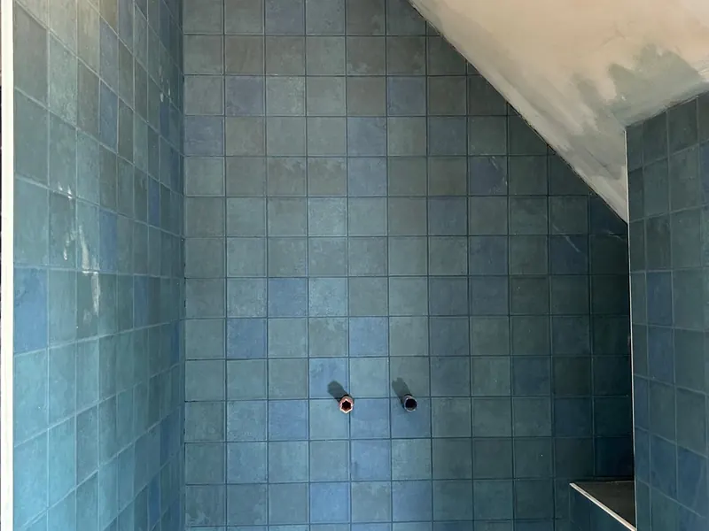 badkamer met blauwe tegels en handdoekradiator