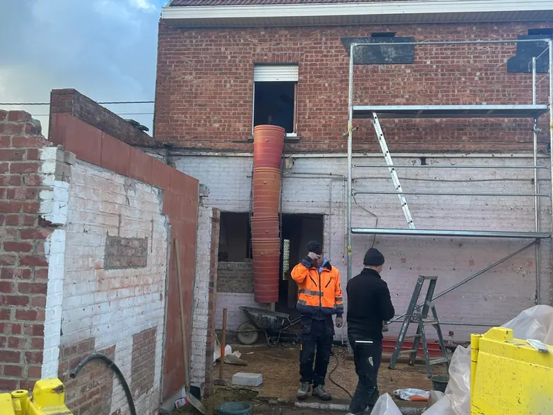 Woning voor de werken, met de ploeg bij de steiger, bij het project in Leuven