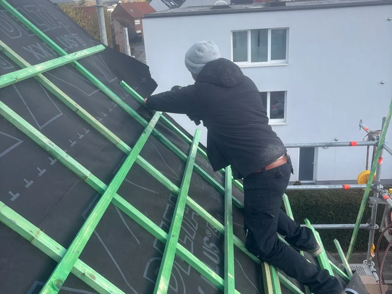dakwerker op onderdak met tengellatten, blauwe lucht