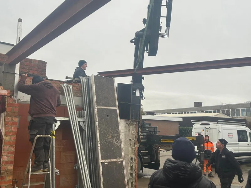 ploeg plaatst stalen ligger met kraan