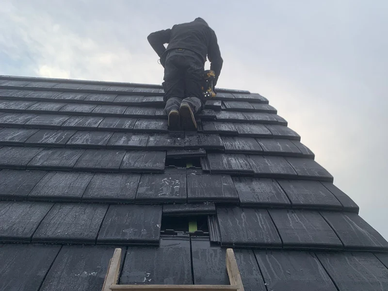 dakwerker legt pannen op ladder