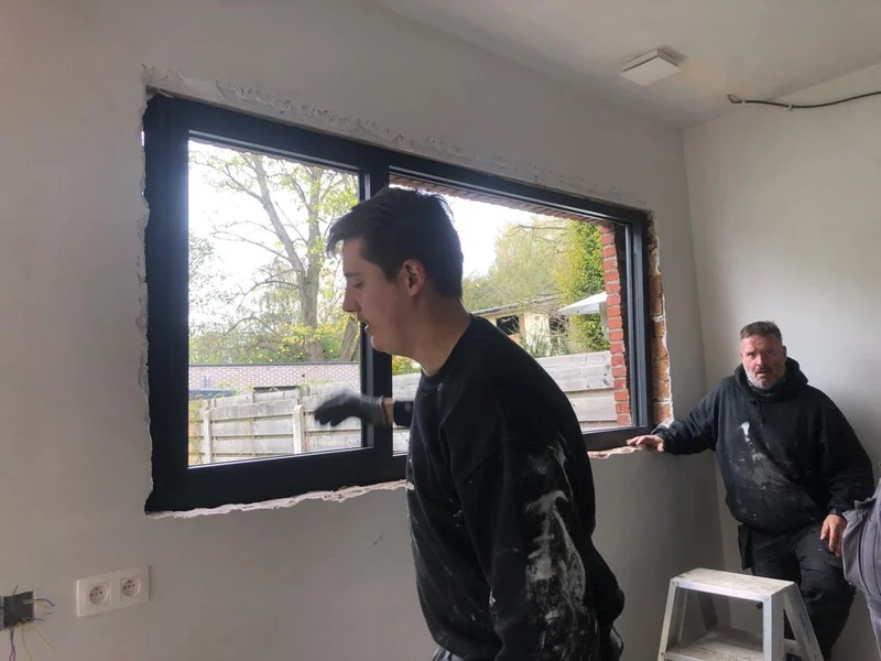 vakman plaatst nieuw zwart raam
