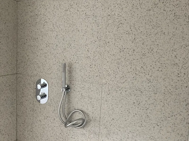 douche met terrazzo-tegels en kraanwerk