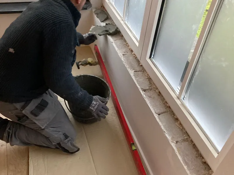 vakman stelt raam binnen af