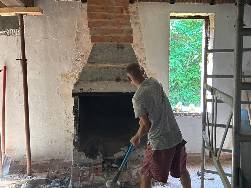 vakman breekt oude schouw uit