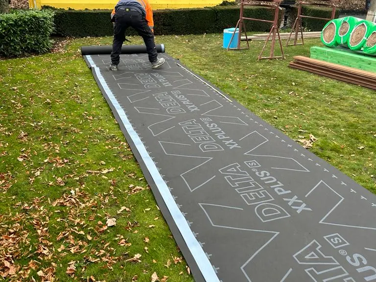 Nieuw onderdakmateriaal klaargelegd in de tuin voor de dakrenovatie in de regio Leuven