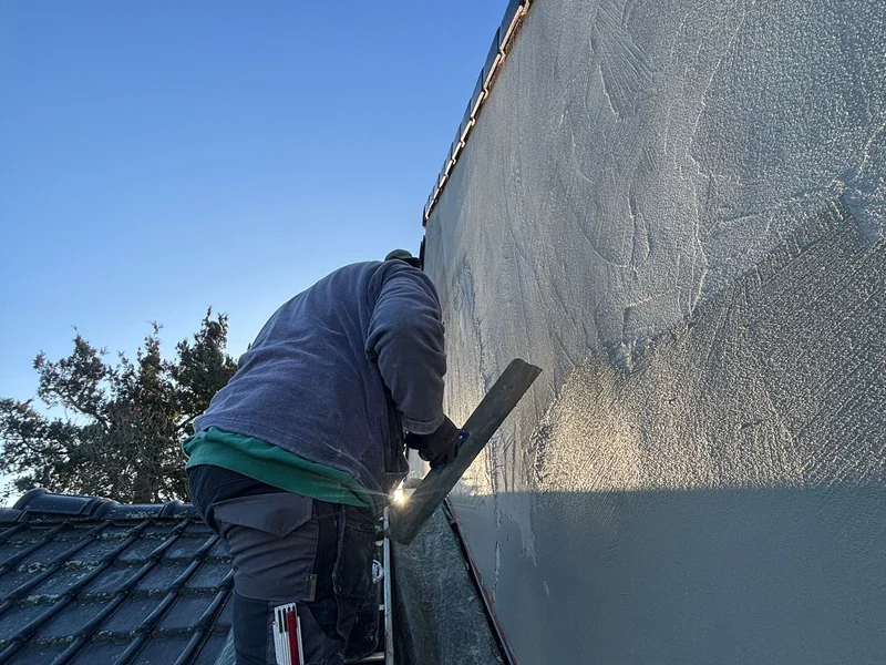 vakman bepleistert gevel op dak