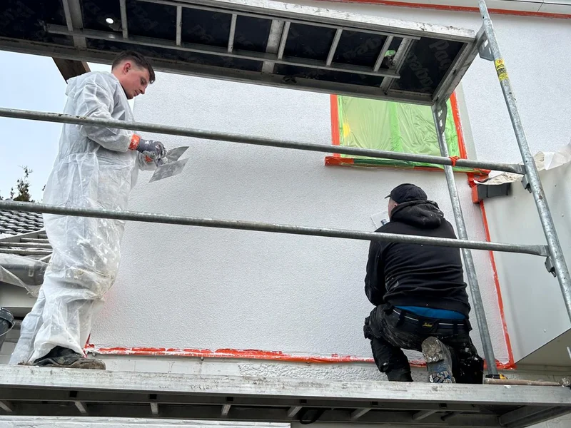 twee vaklui in witte pakken zetten crepi
