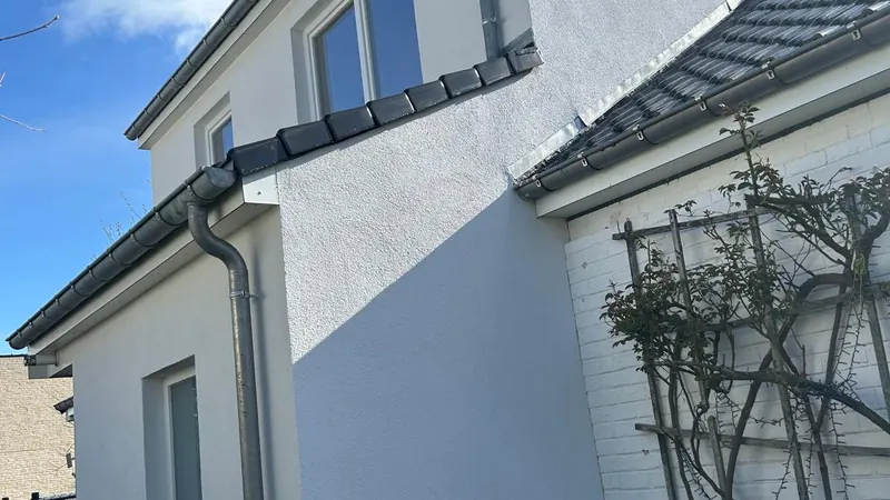 afgewerkte witte woning met nieuwe verdieping, blauwe lucht