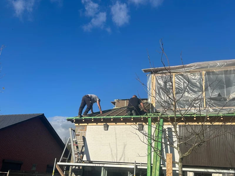 vakman op het dak bij dakuitstek met isolatie