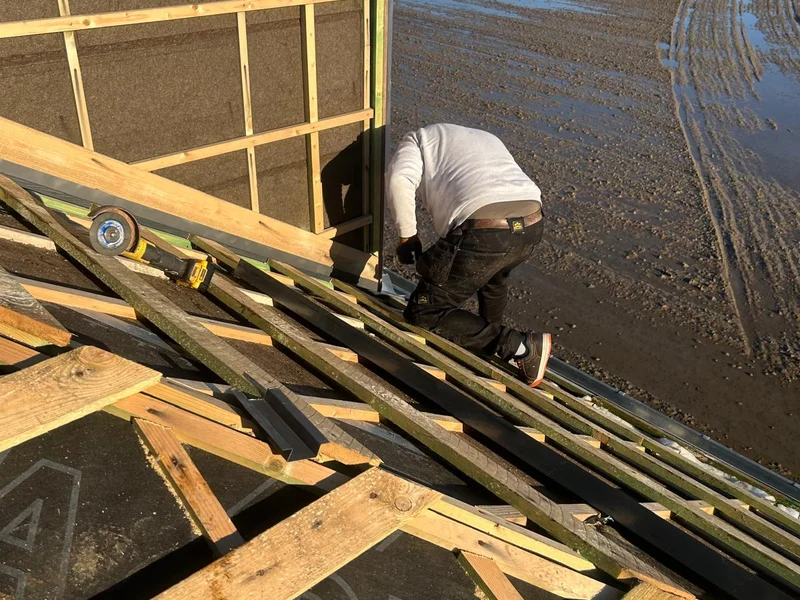 dakwerker legt metalen felsbanen