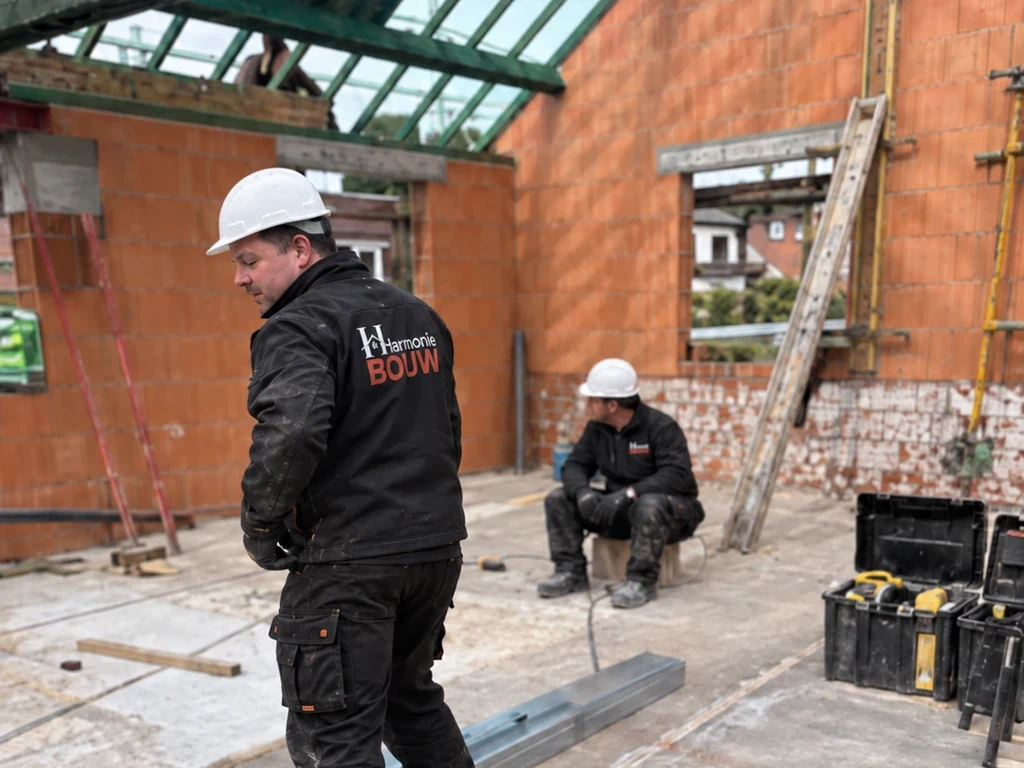 Vakman met helm en bedrijfskledij bij de ruwbouw met stalen liggers